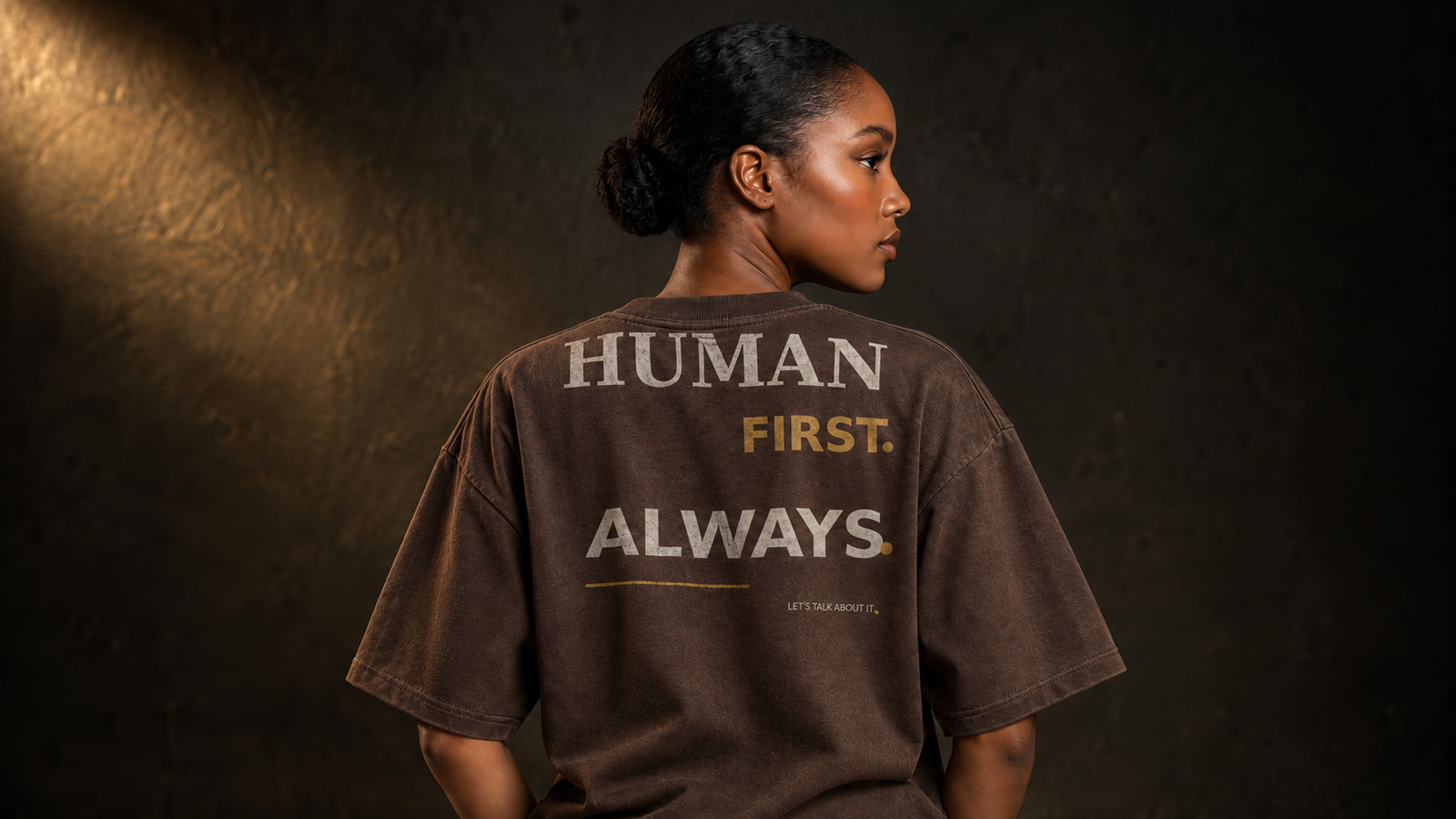 Black model wearing the Human First Always statement tee in Espresso